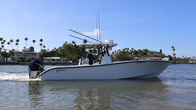 Slide: The Image of 2022 Yellowfin 32 Offshore boat cruising on calm water with palm trees in the background. - 8