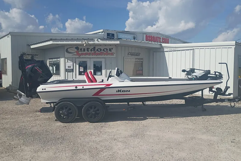 The Image of 2024 iKon LX21 boat on trailer outside dealership under blue sky. - 1