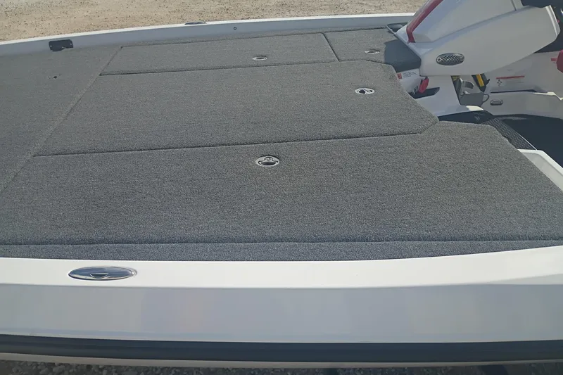 Slide: The Image of 2024 iKon LX21 boat deck with gray carpet and storage compartments. - 10