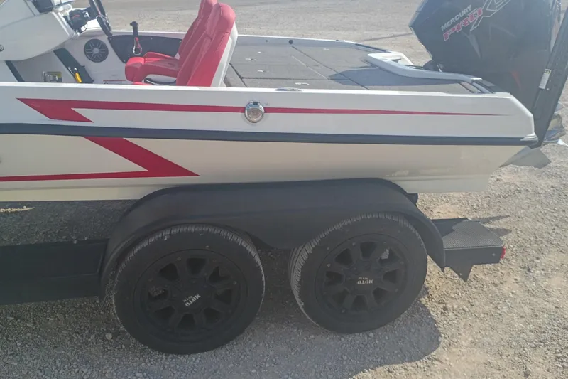 Slide: The Image of 2024 iKon LX21 boat on trailer with red accents and Mercury engine. - 3