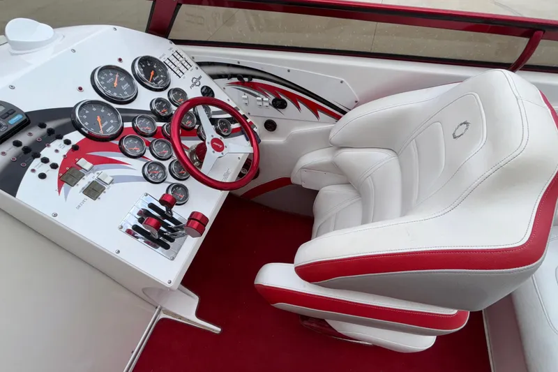 Slide: The Image of 2007 Fountain 38 Lightning boat cockpit with red and white interior, gauges, and steering wheel. - 21