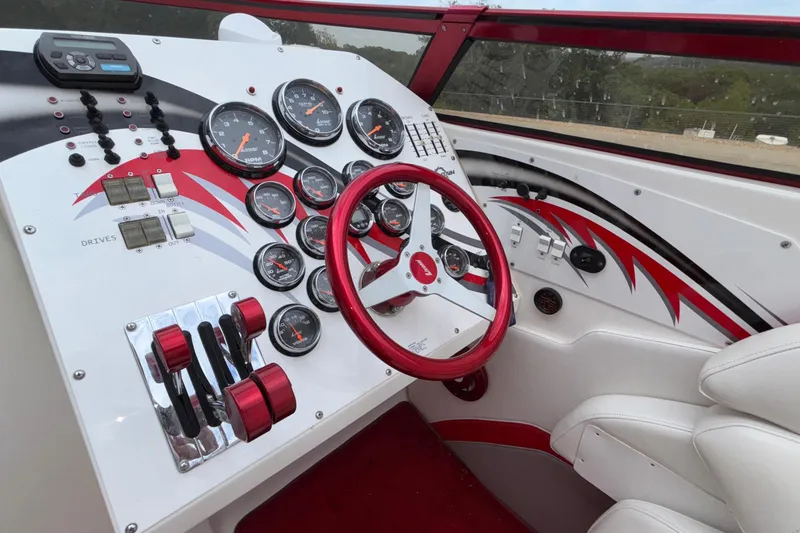 Slide: The Image of 2007 Fountain 38 Lightning boat dashboard with gauges, red accents, and steering wheel. - 22