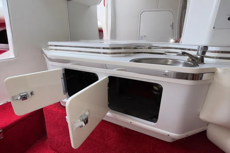 Slide: The Image of 2007 Fountain 38 Lightning boat interior with sink, open cabinets, and red carpet. - 41