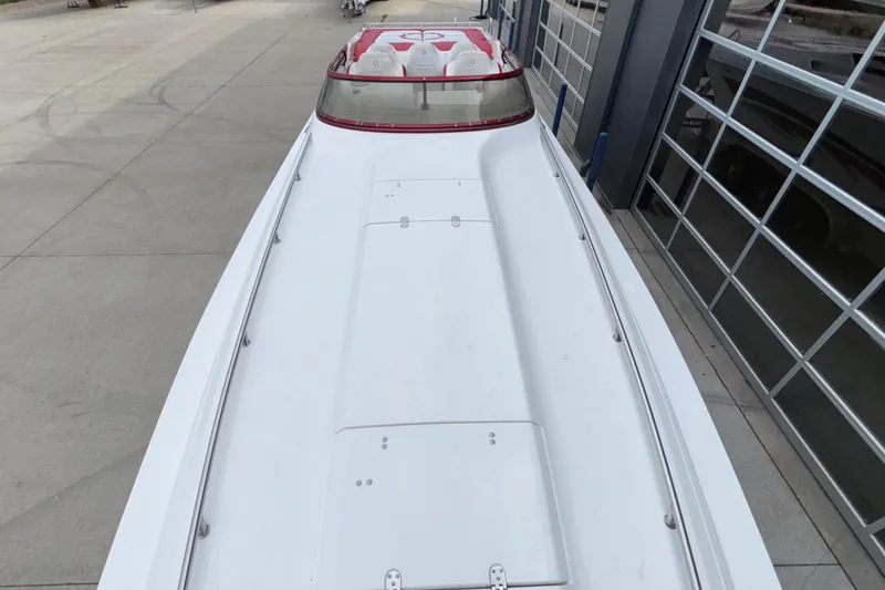 Slide: The Image of 2007 Fountain 38 Lightning boat, white with red accents, docked near a modern garage. - 47