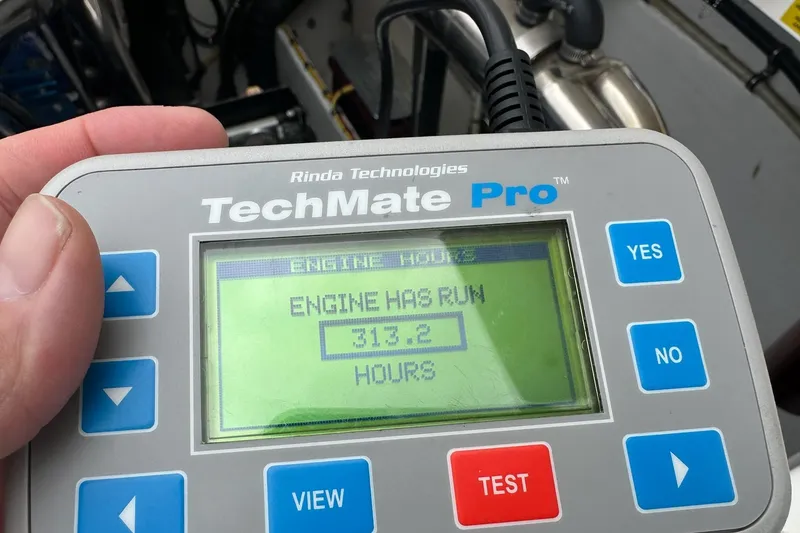 Slide: The Image of Hand holding TechMate Pro device showing 313.2 engine hours for 2007 Fountain 38 Lightning. - 52