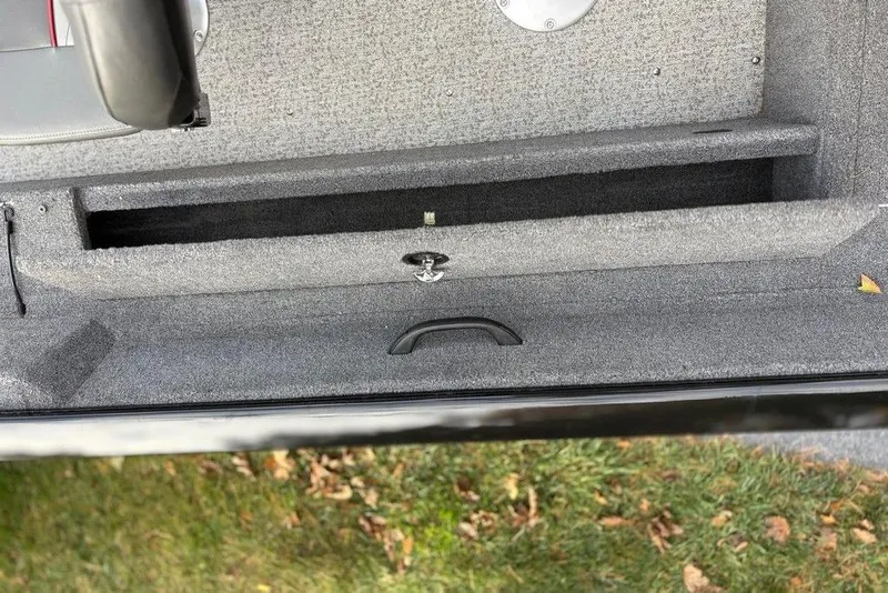 Slide: The Image of 2023 Tracker Pro Guide V-16 SC boat interior storage compartment with gray carpeting. - 12
