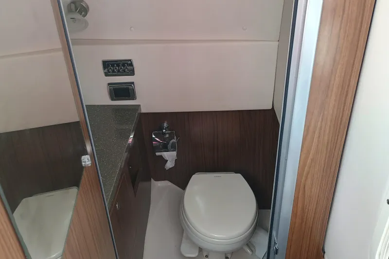 Slide: The Image of 2019 Four Winns H350 boat bathroom with modern fixtures and wood paneling. - 16