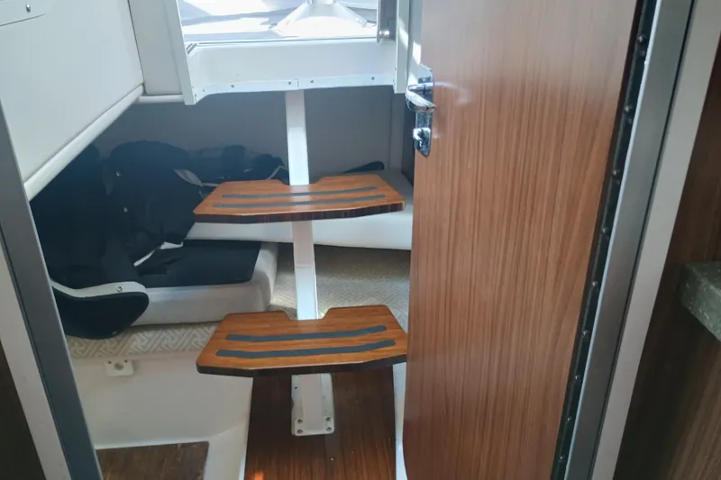 Slide: The Image of Interior cabin of 2019 Four Winns H350 boat with wooden steps and seating area. - 18
