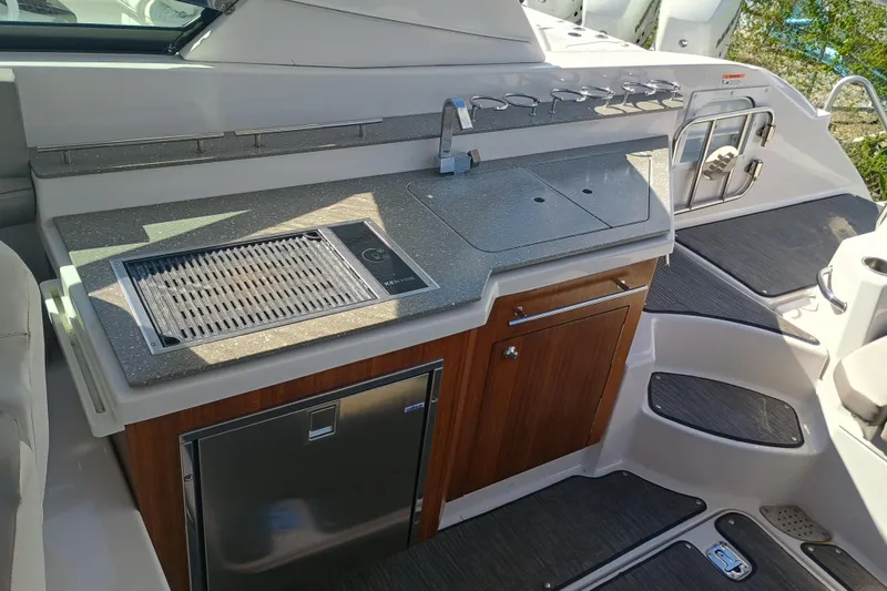 Slide: The Image of 2019 Four Winns H350 boat kitchen with grill, sink, and storage cabinets. - 27