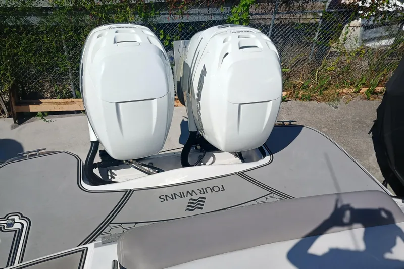 Slide: The Image of 2019 Four Winns H350 boat with dual outboard engines, docked outdoors. - 29