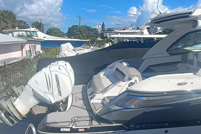 Slide: The Image of 2019 Four Winns H350 boat with Mercury outboard engine, docked under a clear blue sky. - 4