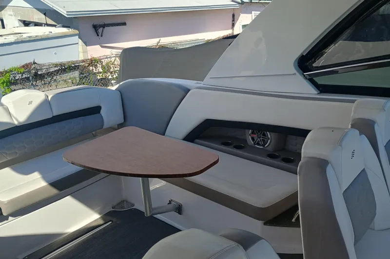 Slide: The Image of 2019 Four Winns H350 boat interior with seating and table, showcasing luxury design. - 7