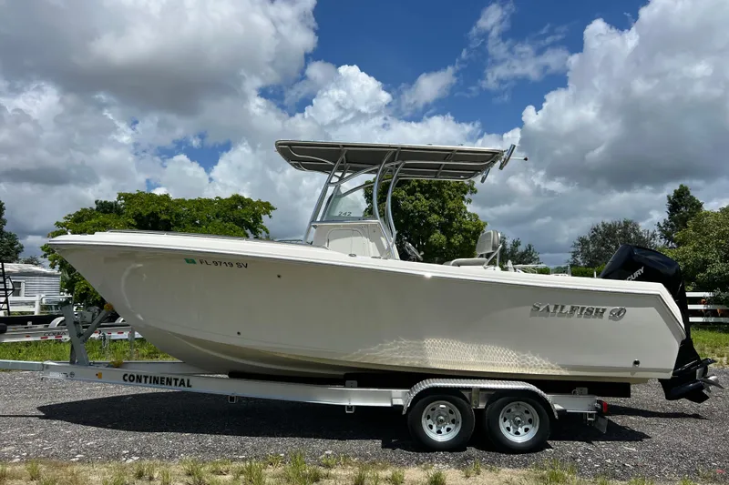 Slide: The Image of 2021 Sailfish 242 CC boat on trailer under cloudy sky. - 1