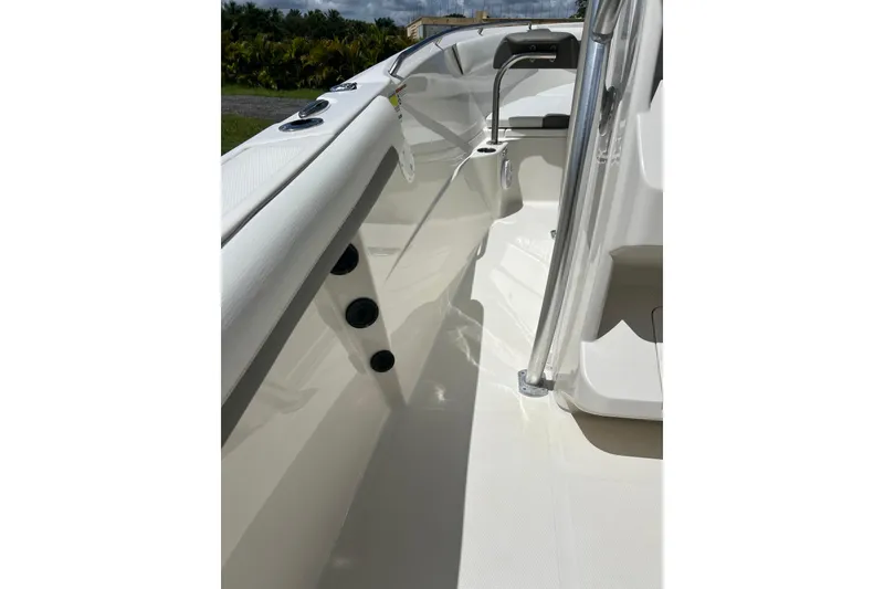 Slide: The Image of 2021 Sailfish 242 CC boat interior with sleek white deck and stainless steel railing. - 18