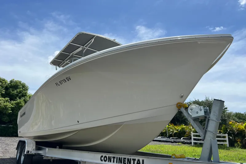 Slide: The Image of 2021 Sailfish 242 CC boat on trailer under clear blue sky. - 4