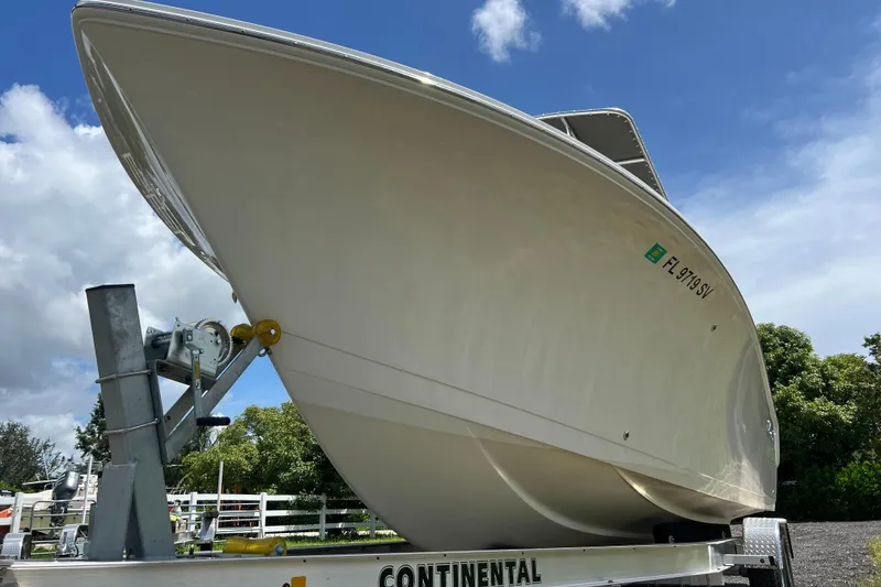 Slide: The Image of 2021 Sailfish 242 CC boat on trailer under blue sky. - 5