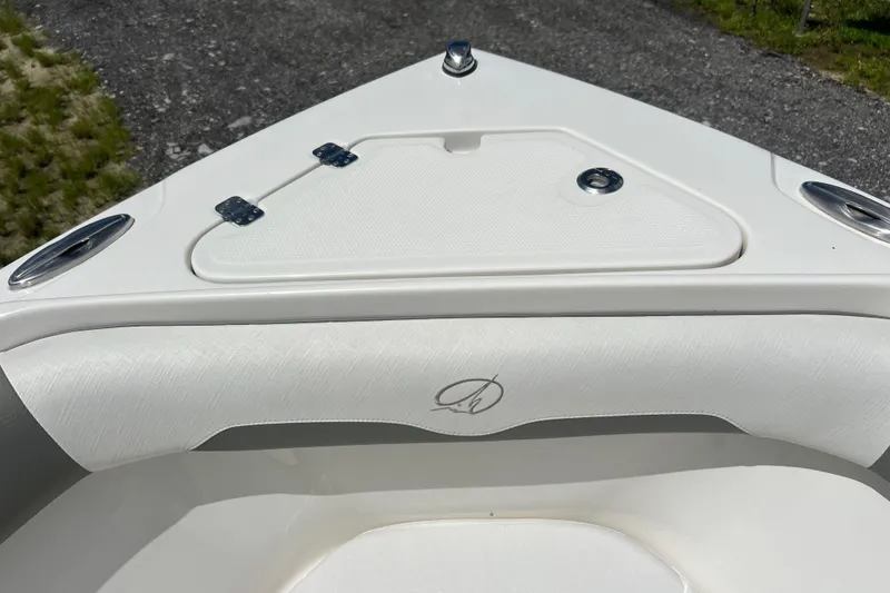 Slide: The Image of 2021 Sailfish 242 CC boat bow with white cushioned seating and storage compartment. - 8