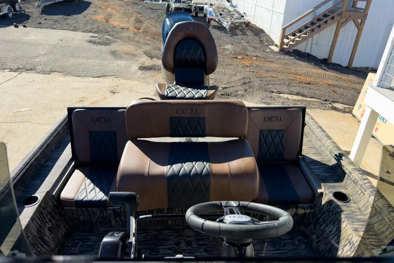 Slide: The Image of 2026 Excel 220 Bay Pro Elite boat interior with open storage compartment and cushioned seating. - 10