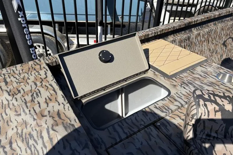 Slide: The Image of 2026 Xpress H210B Bay boat interior with open storage compartment and camouflage design. - 11