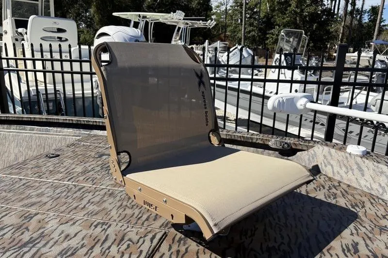 Slide: The Image of 2026 Xpress H210B Bay boat seat with camouflage pattern, docked near other boats. - 14