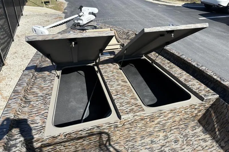Slide: The Image of 2026 Xpress H210B Bay boat with open storage compartments and camouflage design. - 5