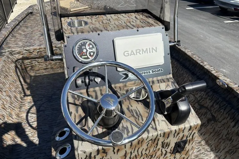 Slide: The Image of 2026 Xpress H210B Bay boat dashboard with Garmin navigation and steering wheel. - 7