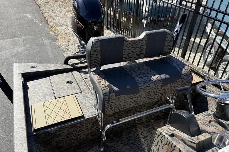 Slide: The Image of 2026 Xpress H210B Bay boat interior with patterned seating and Yamaha outboard motor. - 8