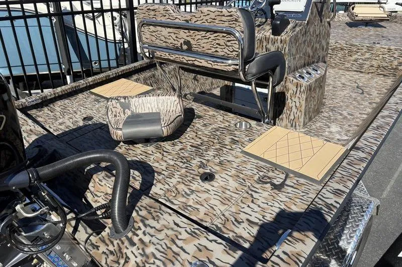 Slide: The Image of 2026 Xpress H210B Bay boat with camouflage design and seating, docked outdoors. - 9