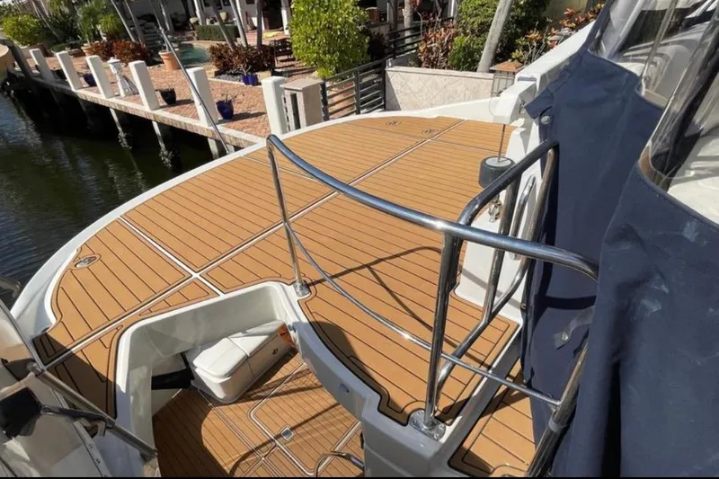 Slide: The Image of 2005 Carver 56 Voyager yacht deck with wooden flooring and metal railings. - 15