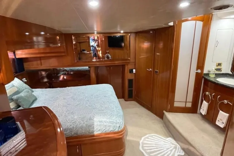 Slide: The Image of Luxurious 2005 Carver 56 Voyager yacht bedroom with elegant wood finishes and cozy bedding. - 19