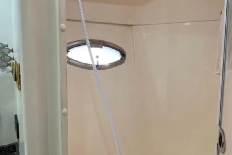 Slide: The Image of Shower area inside 2005 Carver 56 Voyager yacht, featuring a porthole window. - 27