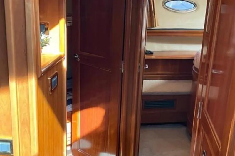 Slide: The Image of Interior of 2005 Carver 56 Voyager yacht, featuring polished wood and cozy cabin space. - 18