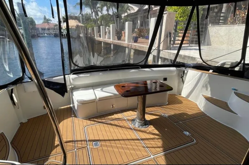 Slide: The Image of 2005 Carver 56 Voyager yacht interior with seating and wooden table, dockside view. - 4