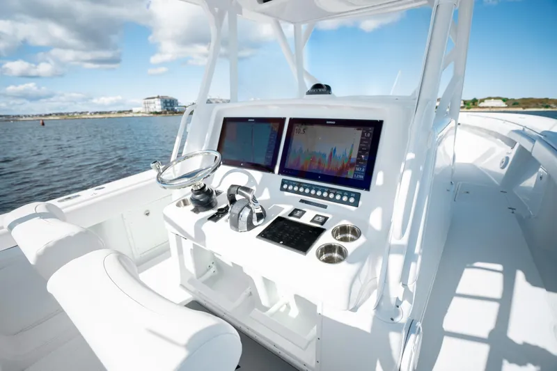 Slide: The Image of 2014 Yellowfin 39 Offshore boat dashboard with dual screens and steering wheel. - 21