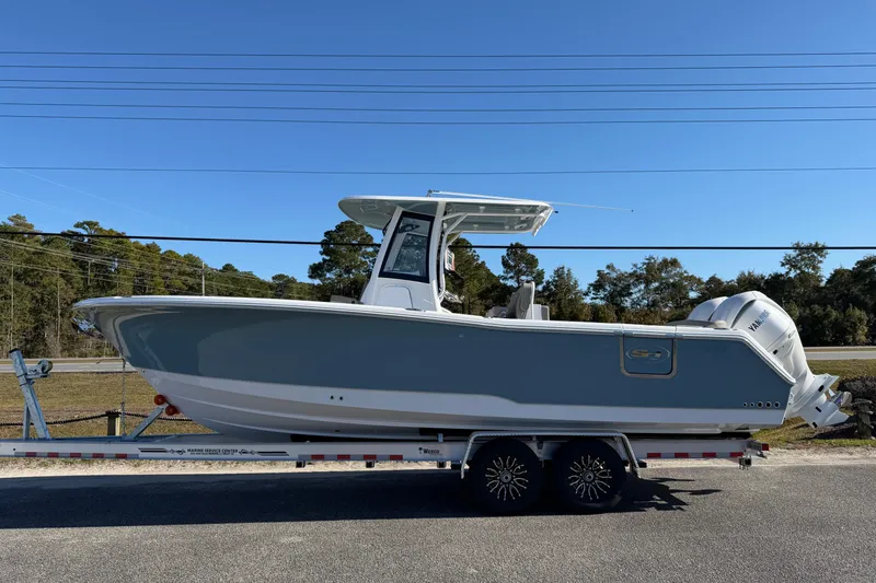 Slide: The Image of 2026 Sea Hunt Ultra 275 Coffin Box boat on trailer, side view, clear sky background. - 2