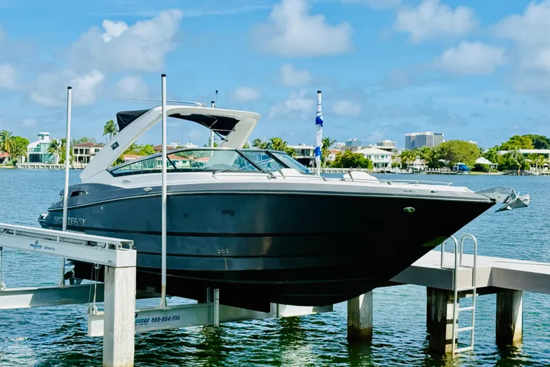 The Image of 2020 Monterey 328SS Super Sport boat on lift by waterfront homes. - 0