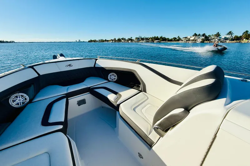 Slide: The Image of 2020 Monterey 328SS Super Sport boat interior on a sunny day, with water and jet ski. - 17