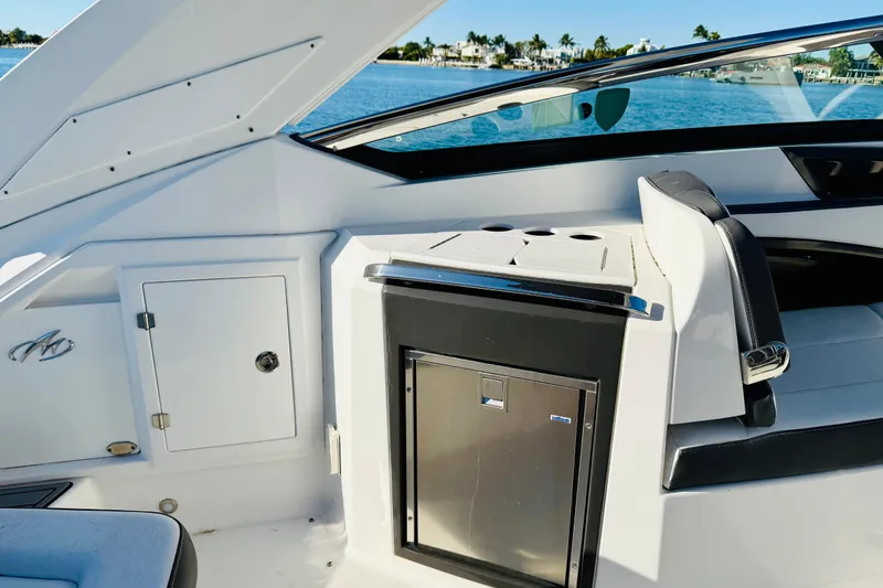 Slide: The Image of 2020 Monterey 328SS Super Sport boat interior with seating and storage, near water. - 19