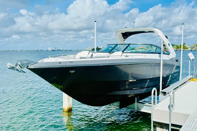 Slide: The Image of 2020 Monterey 328SS Super Sport boat docked on a sunny day by the water. - 2