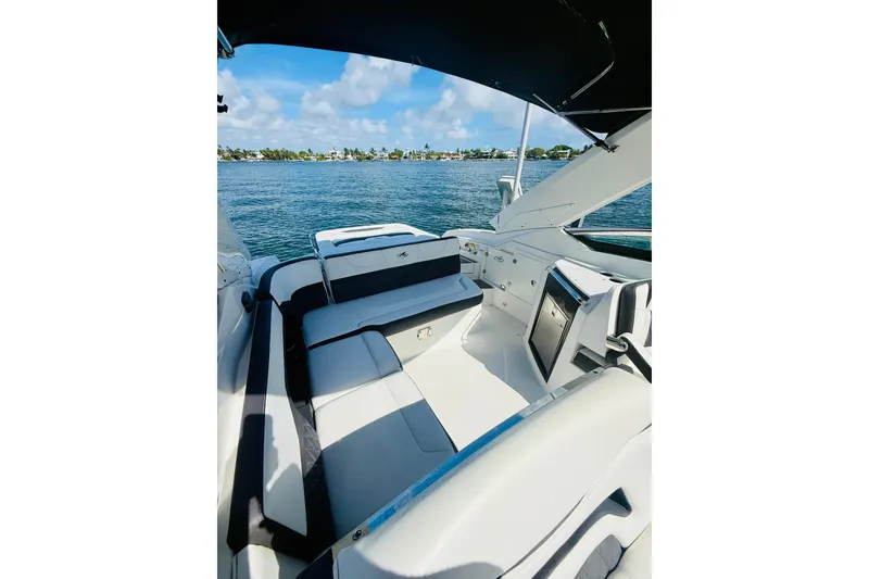 Slide: The Image of 2020 Monterey 328SS Super Sport boat interior with seating, overlooking serene water and blue sky. - 31