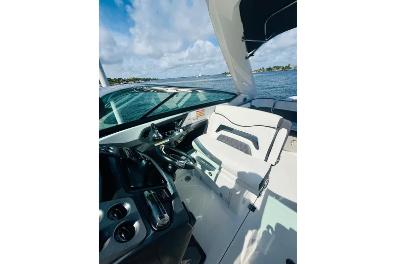 Slide: The Image of 2020 Monterey 328SS Super Sport boat interior with steering wheel and seating, on a sunny day. - 32