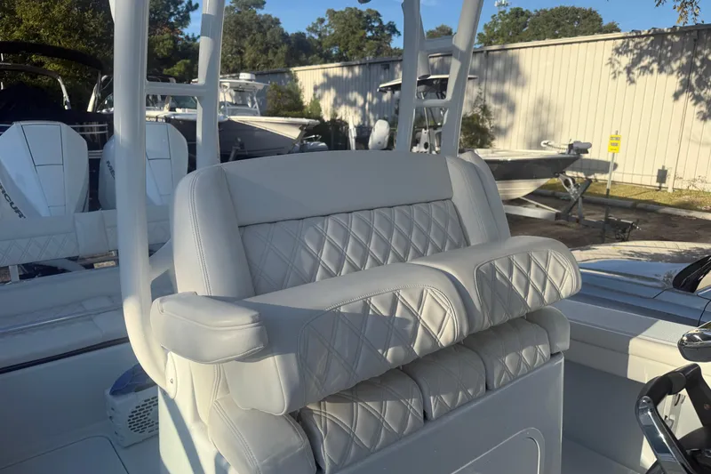 Slide: The Image of 2022 Yellowfin 26 Hybrid boat with luxurious quilted seating in a marina setting. - 4