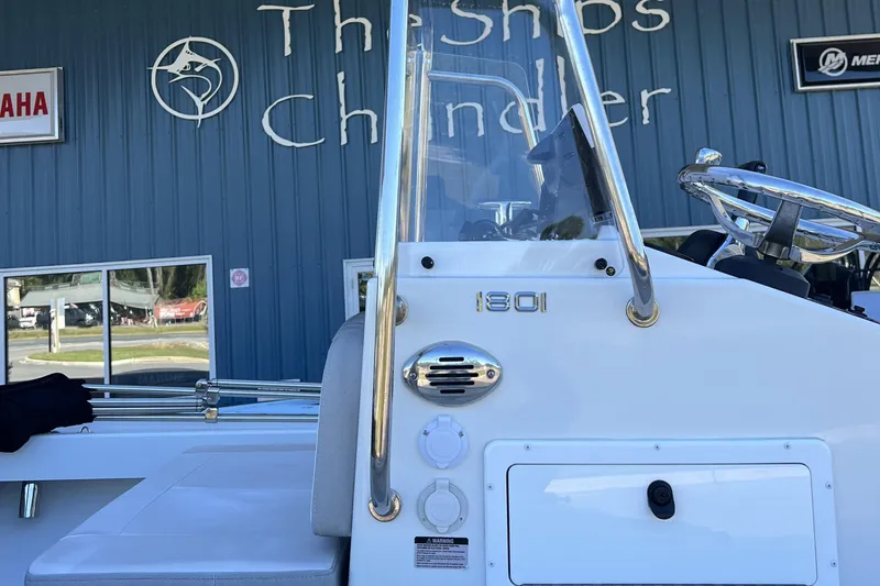 Slide: The Image of 2023 Parker 1801 Center Console boat at marine shop, featuring steering wheel and controls. - 12