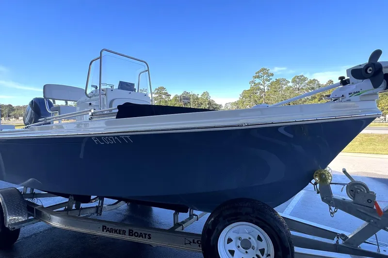 Slide: The Image of 2023 Parker 1801 Center Console boat on trailer, blue hull, clear sky background. - 23