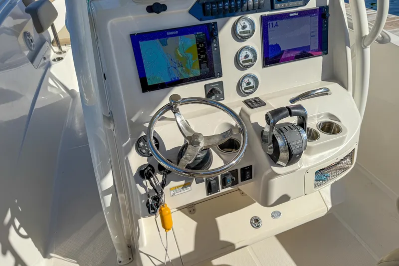 Slide: The Image of 2017 Sailfish 290 CC boat dashboard with navigation screens and controls. - 12