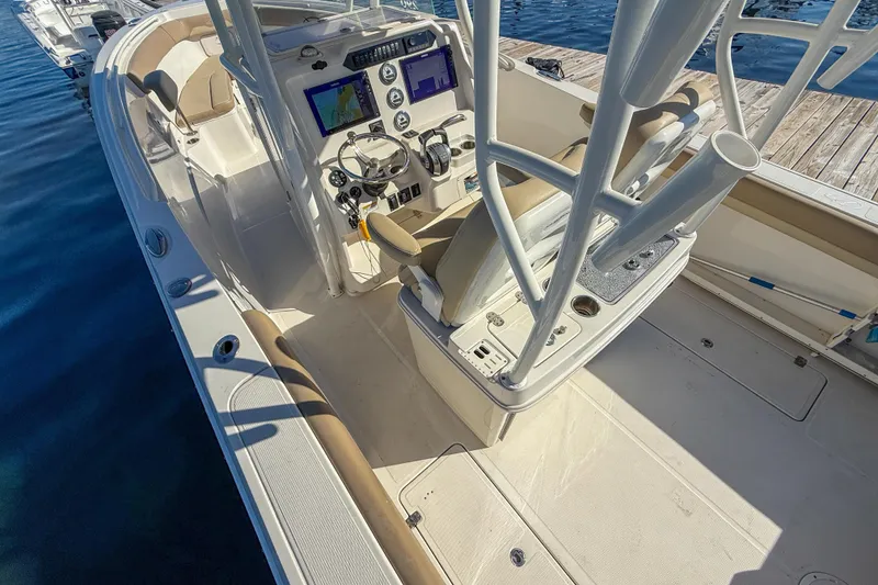 Slide: The Image of 2017 Sailfish 290 CC boat interior with helm, dual screens, and seating. - 14