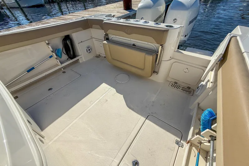 Slide: The Image of 2017 Sailfish 290 CC boat deck with seating and storage, docked by the water. - 18