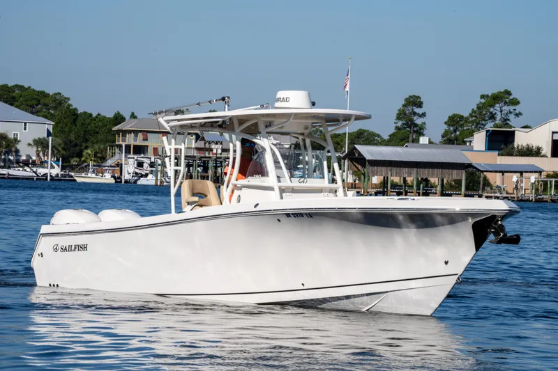 Slide: The Image of 2017 Sailfish 290 CC boat on water near docks and houses. - 2