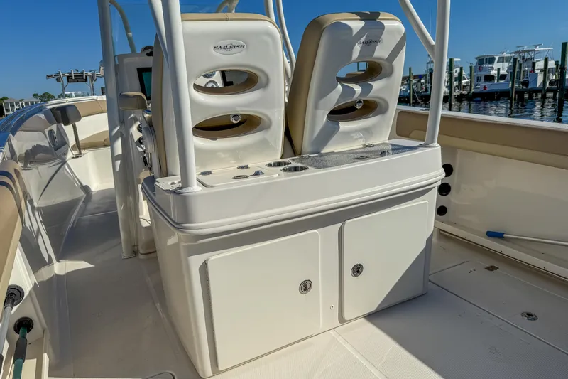 Slide: The Image of 2017 Sailfish 290 CC boat interior with seating and storage, docked at marina. - 21