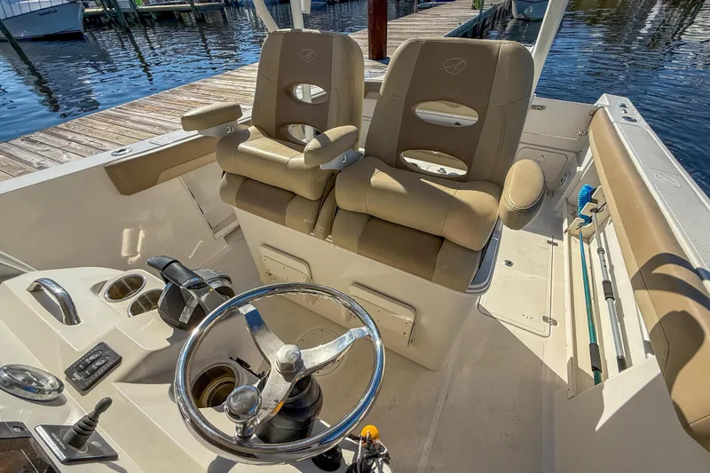 Slide: The Image of 2017 Sailfish 290 CC boat interior with dual captain's chairs and steering wheel. - 23